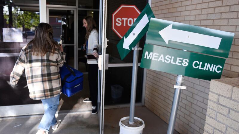 FILE - Health department staff members enter the Andrews County Health Department measles...