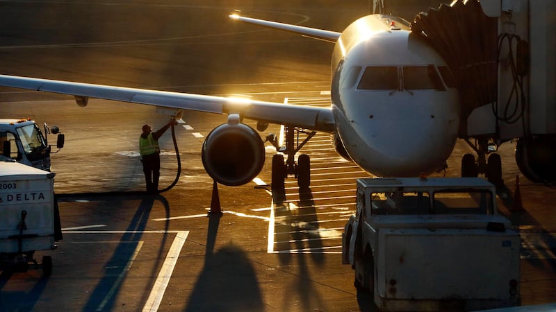FILE - A worker fuels a passenger jet at Logan International Airport, Dec. 8, 2018, in Boston.