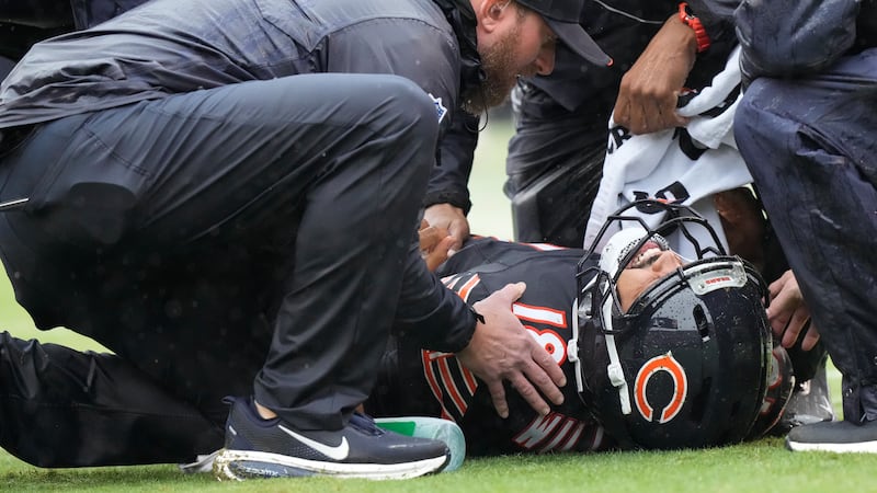 Chicago Bears quarterback Caleb Williams (18) lies on the field during the second half of an...