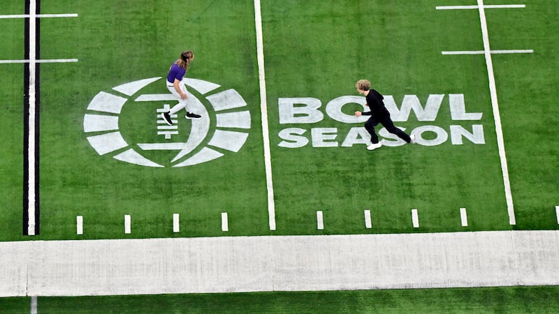 People run on the field over a "bowl season" logo before the Las Vegas Bowl NCAA college...