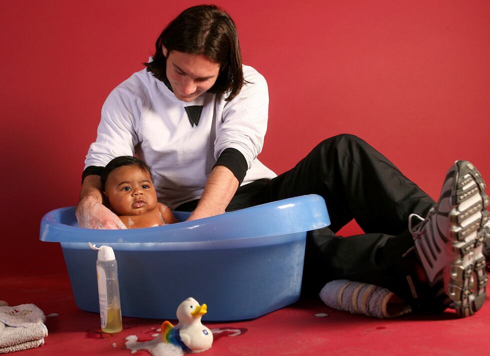 20-year-old soccer star Lionel Messi helps to bathe Lamine Yamal, who was merely six months...