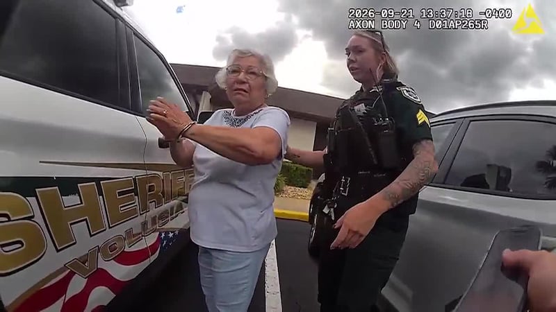 An 80-year-old school worker is accused of striking a student in the back of the head.