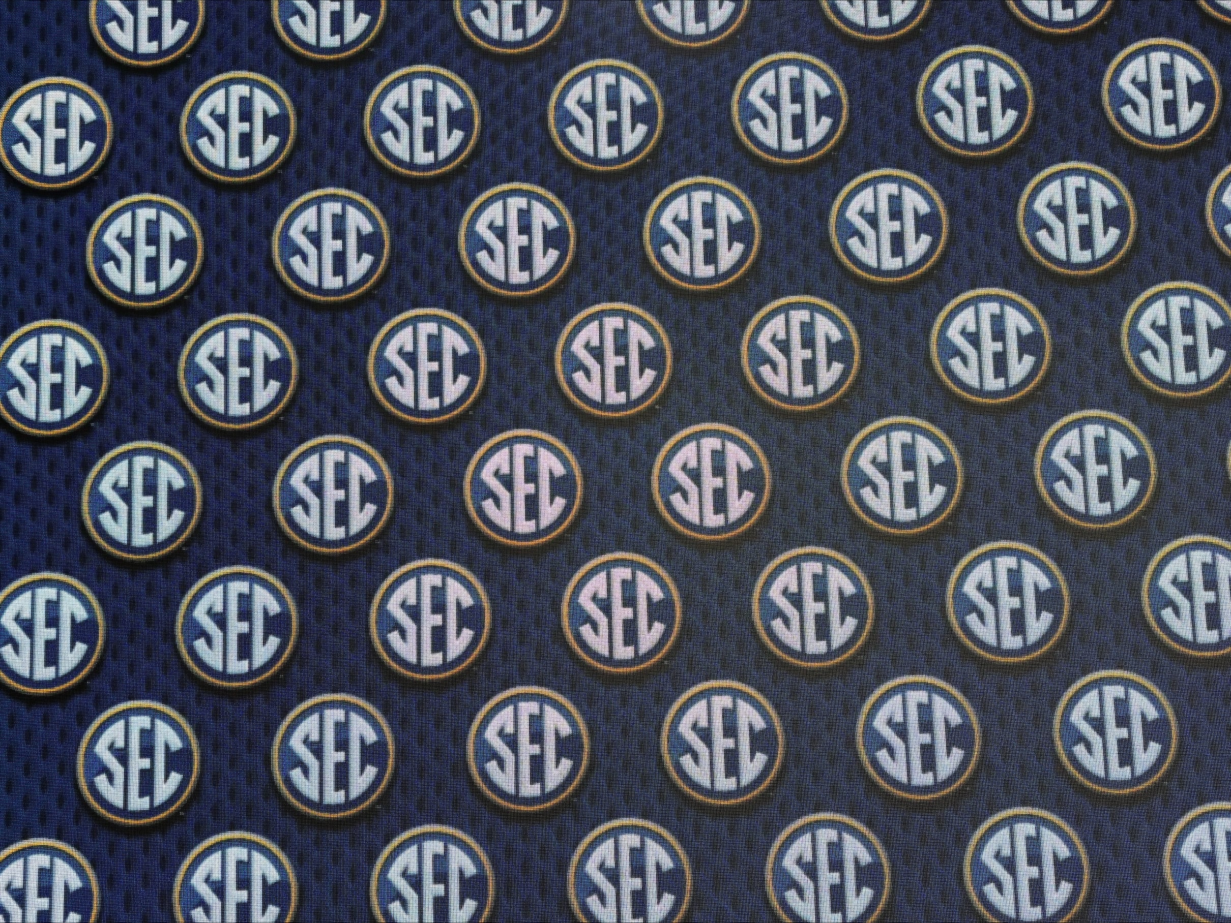 SEC bans former pro athletes from college play , threatens schools with steep penalties