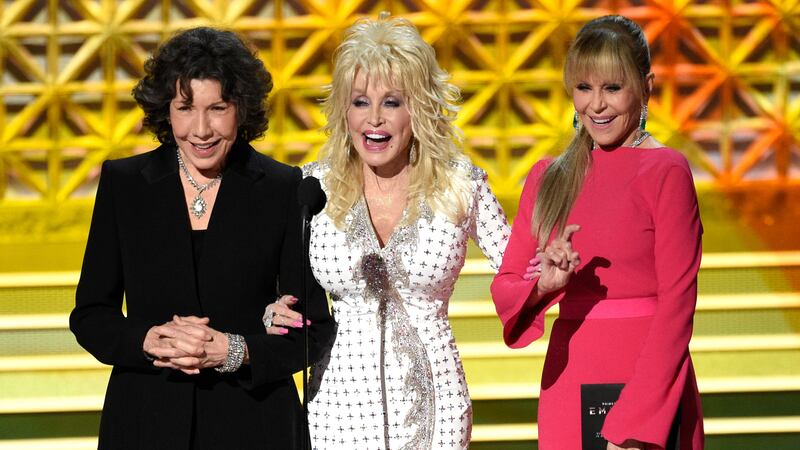FILE - Dolly Parton, center, stands on stage with Lily Tomlin, left, and Jane Fonda at the...