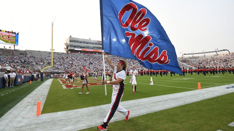 FILE - A cheerleader runs with a flag during an NCAA college football game between Mississippi...