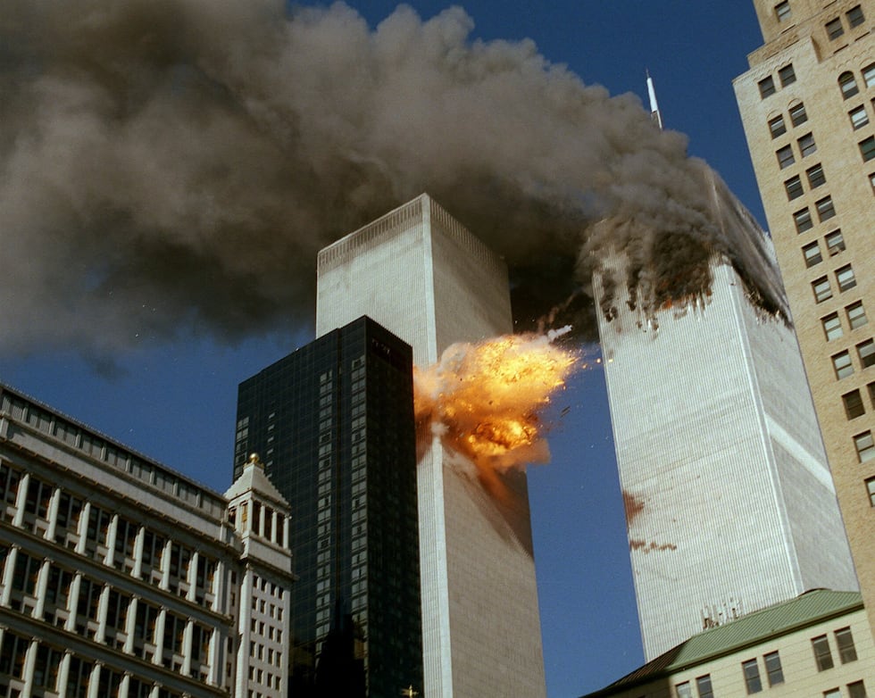 Smoke pours off one of the towers of the World Trade Center as flames explode from the second...