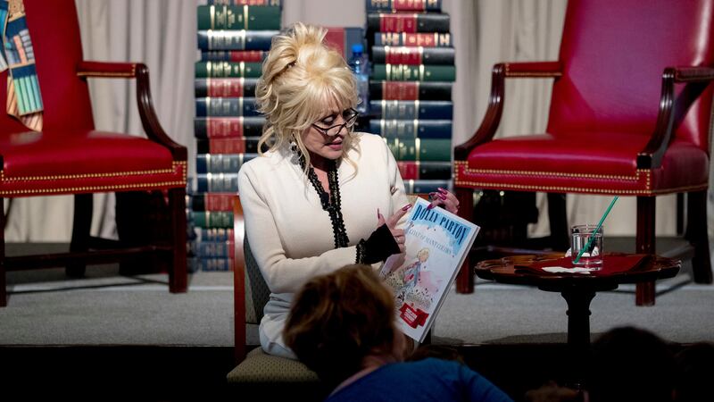 Dolly Parton reads her book "Coat of Many Colors" to children during an an event where her...