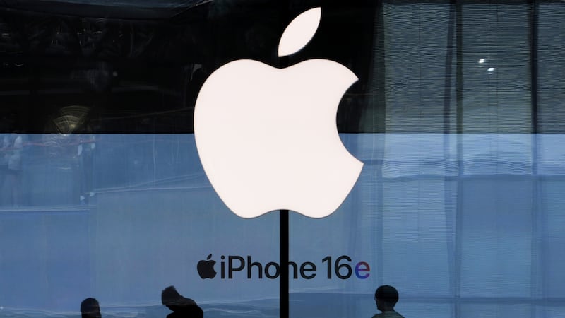 People visit an Apple Store promoting its iPhone 16 at an outdoor shopping mall in Beijing,...